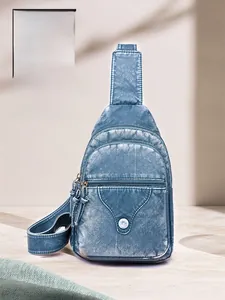 Detail showing vintage blue washed leather texture and multi-layer zippers on a crossbody bag