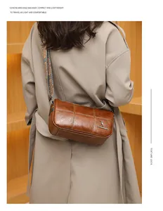 Close-up of brown barrel bag with grid stitching and ethnic style wide woven strap