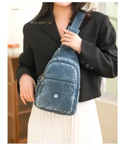 Detail of vintage blue soft leather chest bag with multiple zipper pockets and strap