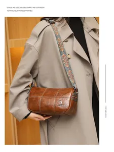 Detail of brown cylinder bag with contrast stitching and bohemian fabric strap