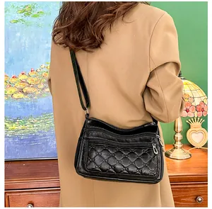 Detailweergave van zwarte gewatteerde crossbodytas met meerdere ritssluitingen