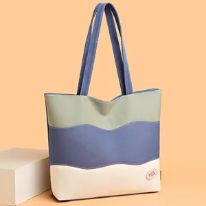 Three-color patchwork canvas bucket bag with wavy stitching and good luck label