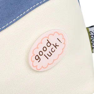 Blue and white canvas bucket bag with wavy pattern and pink good luck patch detail