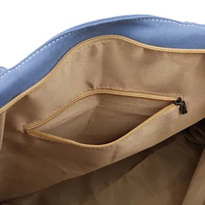 Interior view of blue canvas bucket bag showing khaki lining and zippered pocket