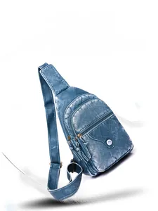 Detail of blue textured faux leather chest bag showing zipper compartments and soft folds