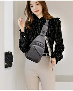 Détail du sac bandoulière gris en cuir souple avec plusieurs zips et large sangle