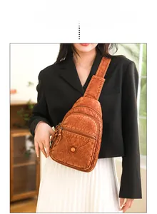 Detail of vintage brown textured leather chest bag with multiple zipper compartments
