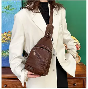 Détail du grand sac de poitrine en cuir marron foncé avec plusieurs poches zippées