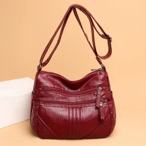 Washed faux leather crossbody bag in dark red with multiple zipper pockets and strap