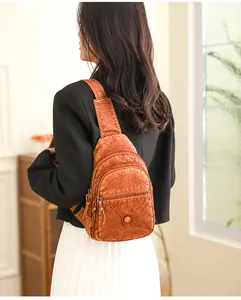 Close-up of brown vintage faux leather crossbody bag with multiple zipper compartments