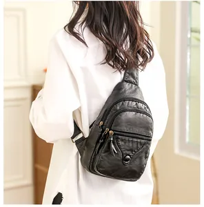 Close-up of a black soft faux leather chest bag showing the adjustable strap and pockets