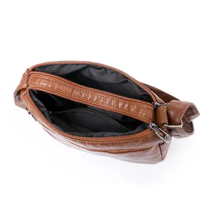 Bruine gewassen leren crossbody tas met meerdere ritsvakken en interne voering