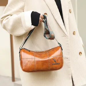 Brown oil wax leather bucket bag with retro stitching and ethnic jacquard strap