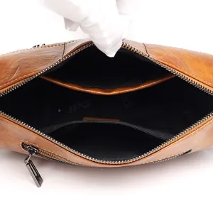Brown waxed leather bucket bag with internal zipper pockets and black fabric lining
