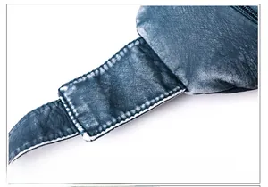 Macro detail of high-density stitching and vintage texture on navy leather chest bag