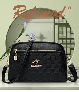 Close-up of black leather crossbody bag with lychee texture and gold kangaroo logo