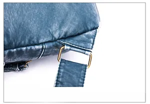Close-up of vintage bronze buckle and high-density leather texture on blue chest bag