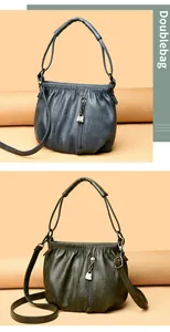 Detail of leather crossbody bags with kangaroo zipper charms in blue-gray and green