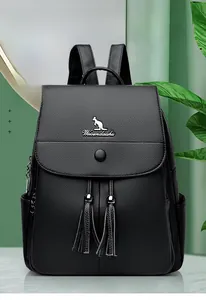 Detail of black pebbled leather backpack with magnetic flap and long tassel accents
