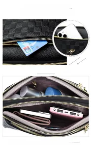 Detailed view of black multi-zip crossbody bag with three compartments and golden logo