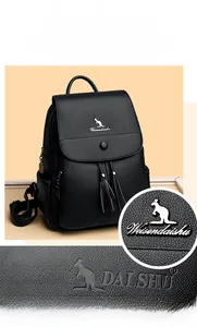 Detail of black pebbled leather backpack showing kangaroo metal logo and tassel accents