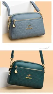 Close-up of textured leather shoulder bag featuring metal kangaroo logo and gold zipper