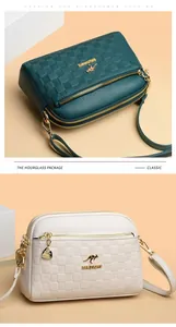 Close-up of litchi grain leather texture and gold kangaroo logo on double zipper crossbody bag