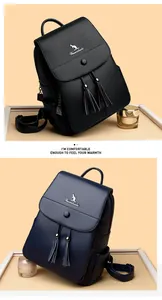 Detail view of leather backpack texture featuring tassel drawstring and metal logo