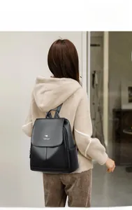 Close-up of black lychee-textured leather backpack featuring a golden kangaroo logo