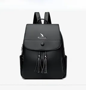 Detailed close-up of a black pebbled leather backpack with kangaroo logo and tassel