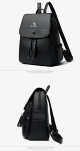 Detail of black pebbled leather backpack featuring a metal kangaroo logo and tassel drawstring