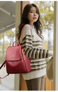 Close-up of dark red pebble leather backpack featuring a kangaroo metal logo and soft texture