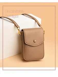Macro detail of Earth-toned litchi grain leather phone bag with gold snap button closure