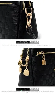 Detail of durable gold metal spring clasp and smooth branded zipper on black leather bag
