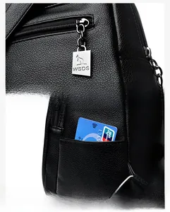 Close-up of black lychee grain leather backpack with metal zipper and side pocket