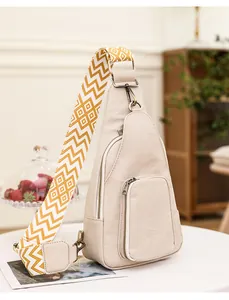 Detail der beige Kunstleder-Brusttasche mit gewebtem Gurt und Bronze-Reißverschlüssen
