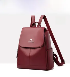 Detail of burgundy lychee-grain faux leather backpack with kangaroo logo and handle
