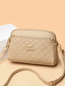 Elegant beige leather crossbody bag with dual zippers and checkered texture pattern