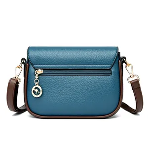 Blue lychee grain leather crossbody bag with brown straps and golden kangaroo pendant