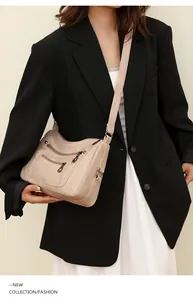 Detail view of stylish beige multi-pocket crossbody bag with soft leather texture