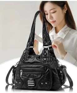 Détail du sac à main noir en similicuir avec design multi-poches et fermetures éclair argentées