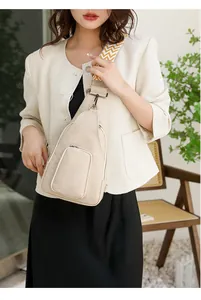 Nahaufnahme der beigen Leder-Brusttasche mit gewebtem Gurt an einem weiblichen Model