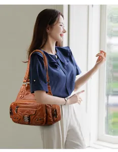 Gros plan d'un sac bandoulière vintage en cuir marron avec plusieurs poches zippées