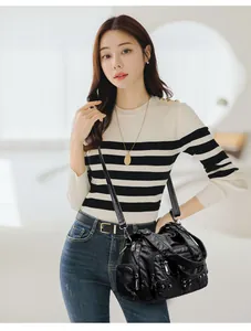 Détail du sac bandoulière en cuir souple noir avec fermetures éclair et multi-poches