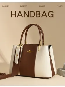 Detail of elegant cream and brown two-tone leather handbag with golden hardware