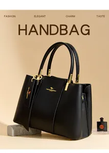 Detail view of black pebble leather handbag with gold metal hardware and brand logo