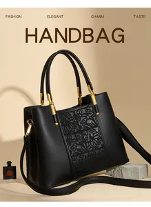 Macro view of black leather handbag with floral embossed panels and gold hardware