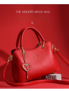Makro-Detail der roten Lederhandtasche mit Känguru-Logo aus Gold und Herzanhänger-Zierde