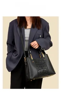 Detail of vintage floral embossing on black lychee grain leather tote bag for women