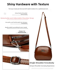 Detail of adjustable and detachable shoulder strap on a brown oil wax leather crossbody bag